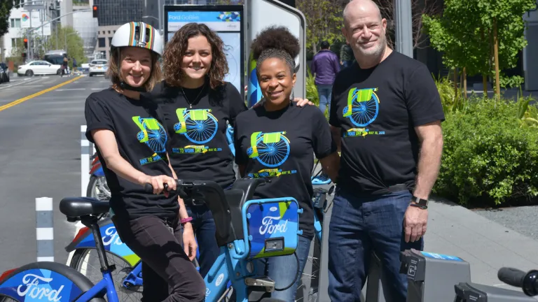 MTC staffers model this year's Bike to Work Day T-Shirt, at the Ford GoBike Station adjacent to MTC's offices at the Bay Area Metro Center in San Francisco. 