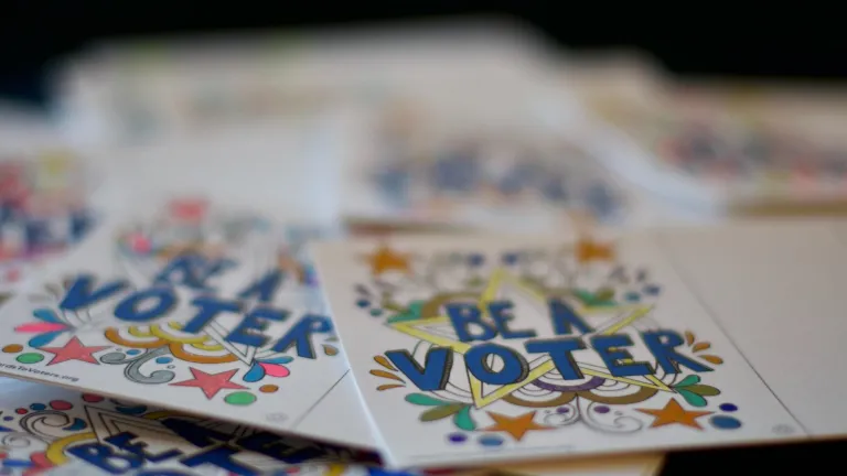 A stack of postcards with illustrations and "Be a voter" message 