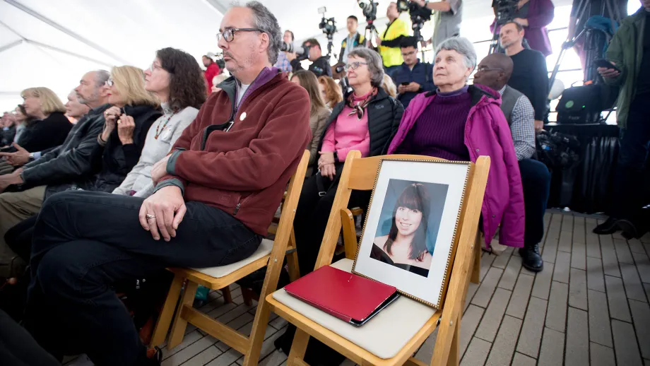 family member sits with portrait of loved one who committed suicide.