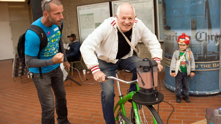 Berkeley Mayor and MTC Commissioner Tom Bates takes a turn at the bicycle-powered smoothie maker at the North Berkeley BART Station. 