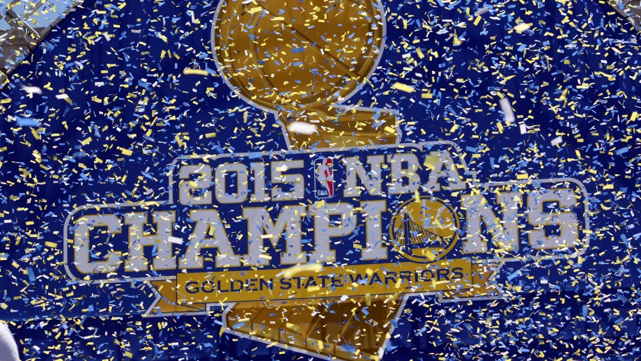 A backdrop displays the Warriors’ new tagline: "2015 NBA Champions." 