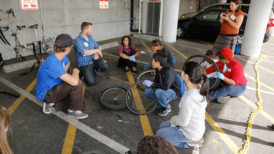 Students learn to fix their own flat tires at a bike repair break-out session.