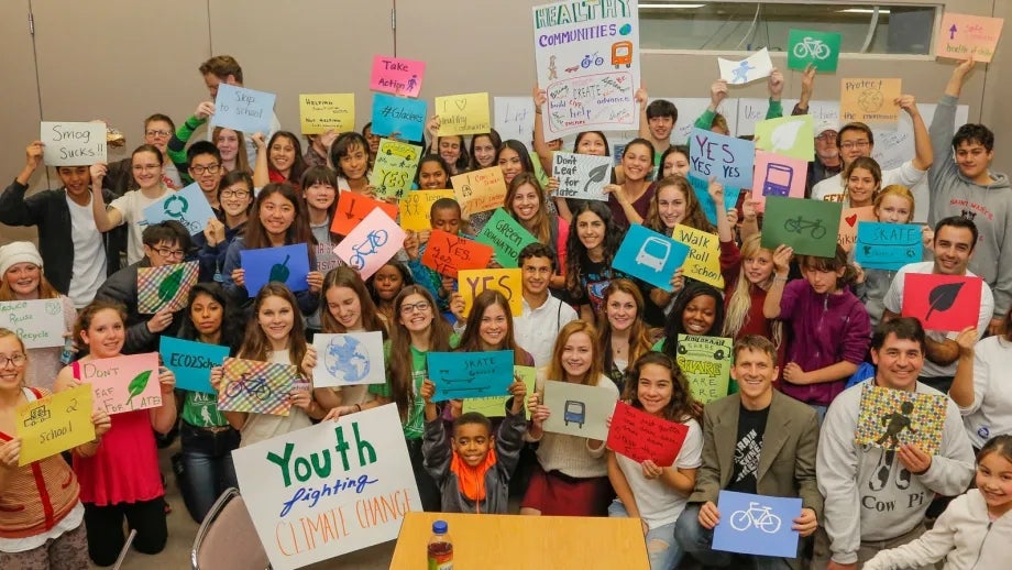 Students gather with signs for a group photo at the 2014 YES Conference
